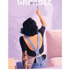 Text: "CAPABLE", "07", Kalendertage darunter. Illustration: Frau von hinten, bemalt lila Wand mit Farbroller.