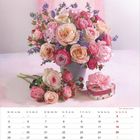 Kalenderseite für Juli mit Blumenarrangement aus Rosen in Rosa und Creme, begleitet von violetten Blüten.