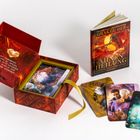 Ein geöffnetes, rotes Kästchen mit Schrift: "Um vererbtes Trauma zu heilen, werden alte Wunden in eine Quelle der Stärke und Weisheit." Daneben liegt ein Buch "Orakel der Ahnenheilung" und einige bunte Karten.