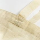 Beiger Stoffbeutel-Ausschnitt, Nahaufnahme der Naht, minimalistisches Design.