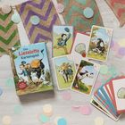 „Das Lieselotte Kartenspiel“, Illustrationen von einer Kuh, einem Briefträger und Bauer auf Karten und einer Verpackung.