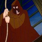 Ein vermummter Charakter in einem braunen Umhang hält ein Seil. Hintergrund: ein Fenster bei Nacht.