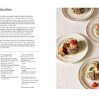 Titel: "German Baumkuchen". Rezeptbeschreibung für einen mehrschichtigen Kuchen aus Marzipan, Ei und Schokolade. Beilage: Fotos von dekorierten Baumkuchen auf Tellern mit Himbeeren.