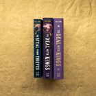 Drei Buchrücken mit den Titeln "TO STEAL FROM THIEVES" und "TO DEAL WITH KINGS" von M.K. Lobb auf goldener Oberfläche.