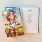 Auf einem Cover steht "Heartland". Daneben eine Farbzeichnung eines Mädchens mit Tieren in ländlicher Umgebung. Seite: "Time Speaks".