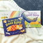 Text: "THE ART OF HOW DOGS SLEEP" und "Alison Kim". Illustration: Hunde schlafen in bunten Farben auf einer Decke.