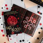 "Jennifer Lynn Barnes - BAD BLOOD" auf einem Buch, Puzzle-Motiv, umgeben von Spielkarten und Puzzleteilen.