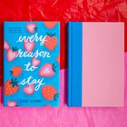 Buchtitel: "Every Reason to Stay" von Lane Clarke, umgeben von Erdbeer-Illustrationen auf blauem Hintergrund.