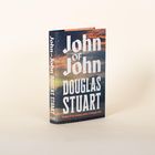 Ein Buch mit dem Titel "John of John" von Douglas Stuart, cover im Hintergrund eines Himmels und Sonnenuntergangs.