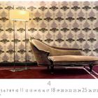 "Recamiere", "CASARES EDITION", Monat 4. Ein hellbraunes Sofa vor einer gemusterten Tapete und eine Stehlampe rechts davon.