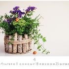 "4 CASA-RES EDITION." Ein rustikales Gefäß mit Blumen und Schnecken auf hellem Hintergrund.