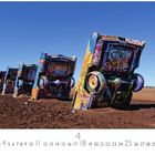 Es steht "Cadillac Ranch". Mehrere bunt bemalte Autos sind halb vergraben in einer Wüstenlandschaft.