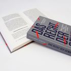 Graues Buch mit Titel: "DAS RECHT DER GEWALT" von Hendrik Simon. Es liegt auf einem geöffneten Buch.
