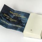 Text: "Berühre nie das Schwert. Öffne nie das Portal. Verliere nie dein Herz." Ein geöffnetes Buch mit einem Poster.