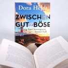 Text auf einem Buchcover: "Dora Heldt, Zwischen Gut und Böse, Karl Sönnigsens letzter Fall". Cover zeigt Leuchtturm und Schafe.