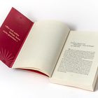 „Wer sich selbst belügt, kann nicht gestalten.“ Offenes Buch mit rotem Buchdeckel, Textpassage auf Seite 13.