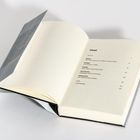 Ein geöffnetes Buch zeigt ein Inhaltsverzeichnis mit Kapiteln zu Nation, Freiheit, Familie, Demokratie, Widerstand. Grauer Einband erkennbar.