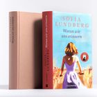 Buchtitel: "Woran wir uns erinnern" von Sofia Lundberg. Cover zeigt eine Frau in einem lila Kleid auf einem Feldweg.