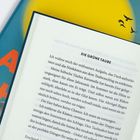 "Die Grüne Taube" beginnt einen Text über Taubenpflege. Eine bunte Buchseite mit Silhouetten von fliegenden Vögeln.