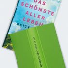Covertext: „DAS SCHÖNSTE ALLER LEBEN“ über Wolkenhimmel. Ein grünes Buch darunter zeigt: „BETTY BORAS DAS SCHÖNSTE“.