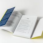 Ein aufgeschlagenes Buch zeigt das Inhaltsverzeichnis mit Titeln wie "Kinderverschwörung" und "Cybermobbing".