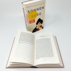 Der Text auf dem Buchdeckel lautet: "Brigitte Glaser - Sonnenberg". Daneben ein aufgeschlagenes Buch.