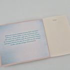 Text: „Hannah trug ein einfaches braunes Kleid...“ Links Text auf bläulichem Hintergrund, rechts leere Seite.