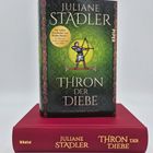 "Juliane Stadler: Thron der Diebe – Die wahre Geschichte von Robin Hood" steht auf einem grünen Buchcover mit Bogenschützen.