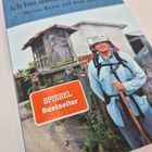 "Ich bin dann mal weg. Meine Reise auf dem Jakobsweg." Roter SPIEGEL Bestseller-Aufkleber. Ein Wanderer mit Stab.