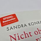 Ein roter Sticker sagt: "SPIEGEL Bestseller Jetzt als Taschenbuch". Darunter steht: "SANDRA KONRAD" und "Nicht ohne".