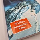 Text: "SPIEGEL Bestseller-Autor" auf einem roten Aufkleber. Hintergrund: Schneebedecktes Gebirge.