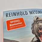 "SPIEGEL Bestseller" und "Reinhold Messner". Cover eines Buches mit Bild eines Mannes mit zerzausten Haaren.
