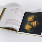 Links Text über Croissants formen, rechts drei Croissants auf dunklem Hintergrund. Buchseiten sind leicht geöffnet.