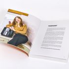 VORWORT. Eine Frau sitzt in der Küche neben einem Airfryer und lächelt in die Kamera.