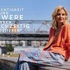 „Leichtigkeit und Schwere können gleichzeitig existieren.“ Frau mit blonder Frisur in orangefarbenem Outfit sitzt draußen.