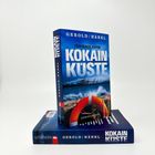 Im Vordergrund steht ein Buch mit dem Titel "KOKAIN KÜSTE". Darauf: ein Rettungsring und stürmische See.