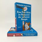 Ein Buchcover mit dem Titel "Eine Prise Glück im Restaurant der verlorenen Rezepte", darauf eine Illustration einer Katze.
