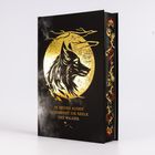 „IN SEINEN AUGEN SCHIMMERT DIE SEELE DES WALDES.“ Goldene Wolfsillustration vor schwarzem Hintergrund, kunstvoller Buchschnitt.