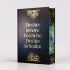 Ein Buch mit goldener Schrift: "Dies hier ist keine Geschichte. Dies hier ist Realität." Verziert mit floralen Mustern.