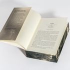 Prolog: Cataclysm; Ein Buch liegt geöffnet, zeigt einen Textauszug aus einem Roman mit einer kosmischen Illustration am Umschlagrand.