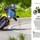 "SUZUKI V-STROM 800 DE", "NEUER ANSATZ." Ein Fahrer auf einem gelben Motorrad fährt eine Kurve, daneben ein Bild des Motorrads.