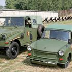 "Typische Szene an der einstigen DDR-Interzonengrenze: Kübelwagen Trabant P 3 und Robur-Mannschaftswagen..." 

Zwei geländegängige Militärfahrzeuge in Olivgrün vor einem Grenzzaun.