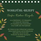 "Wohlfühl-Rezept: Hafer-Kakao-Kugeln. Zutaten: Haferflocken, Kakaopulver, Honig, Mandelmus. Grüne Blätter verzieren."