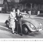 Kalender: April. Zwei Menschen stehen neben einem VW Käfer. Ein Mann hält Schlüssel hoch, daneben eine Frau, beide lächelnd.