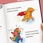 Text: „Wenn es sich mutig fühlt, leuchtet es orange. Und wenn es sich freut, strahlt es in allen Regenbogenfarben.“  
Zwei Dinosaurier-Illustrationen in orange und bunt.