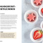 "KOKOSJOGHURT-FRUCHTGUMMIS" steht oben. Rezept mit Zutaten, Anleitung und einem Tipp. Erdbeerförmige Fruchtgummis auf Papier.
