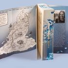 Links eine Karte mit den Worten: "ANNWN" und mehrere Ortsnamen. Rechts ein Buch mit blauem Rücken und Text über eine Autorin.