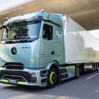 "The New Actros L" steht auf einem großen, modernen Lastwagen mit hellem Führerhaus und Anhänger auf einer Straße.