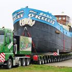 Auf einem großen, spezialisierten LKW wird ein Schiff mit der Aufschrift "SEAN O'KELLEY" transportiert.