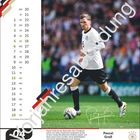 Kalender links, Bild rechts: Pascal Groß im weißen Fußballtrikot, spielend auf Rasen. Großer Schriftzug "Vorjahresabbildung".